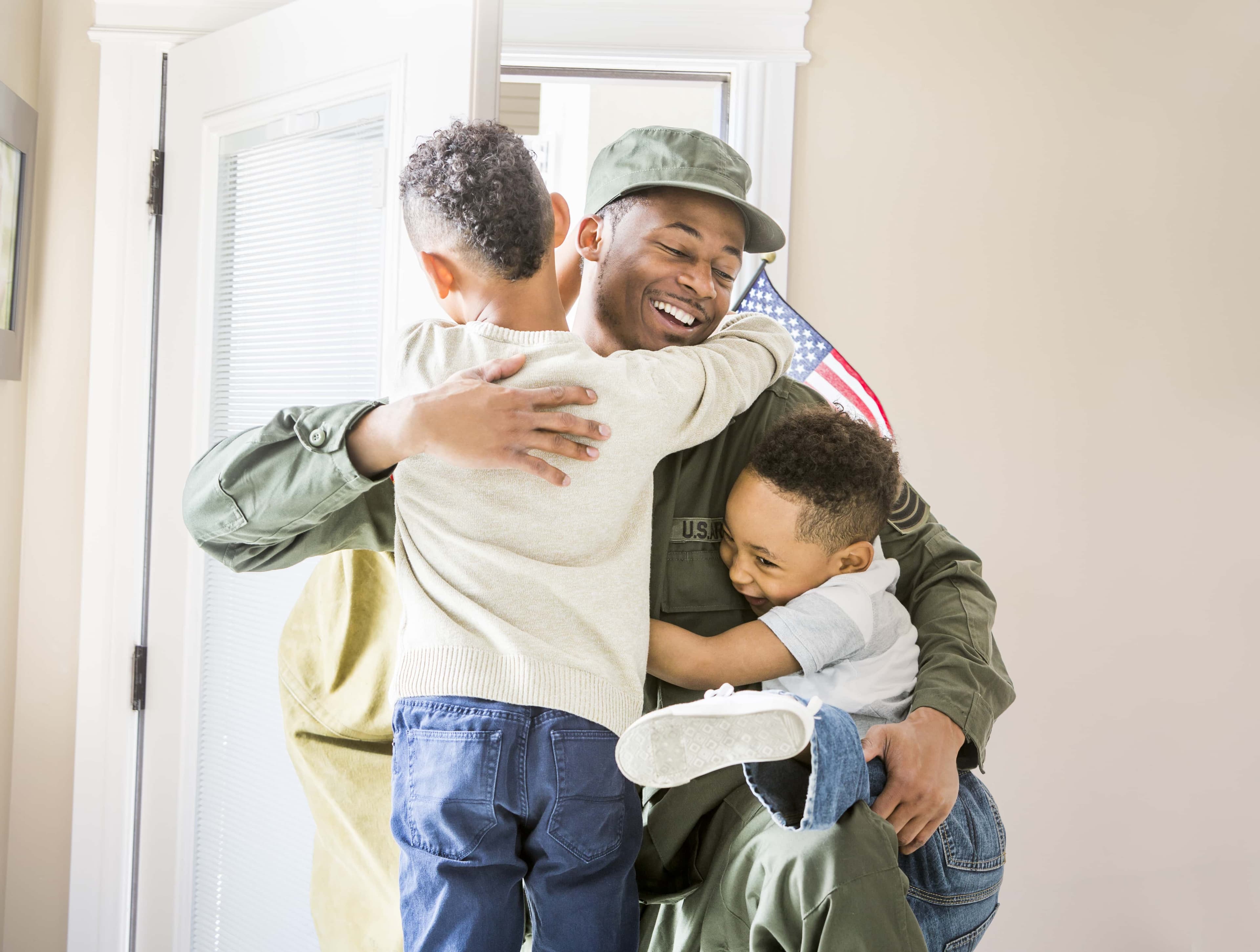 Soldier returning home, hugging kids